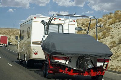 An rv towing a boat on a road trip. Recreational vehicle insurance